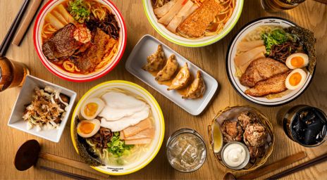 A table of food with ramen and gyozas