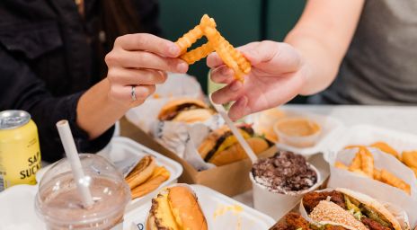 Two people having Friday Burger fries and burgers