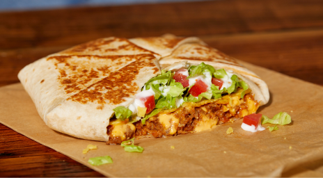 A Taco Bell crunchwrap with beef, cheese, lettuce, sour cream and tomatoes.